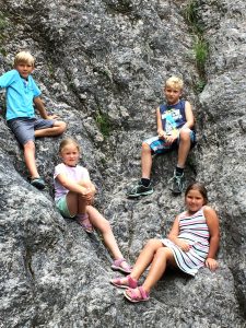 2 Jungen und 2 Mädchen ca. 9 Jahre alt, sitzen in einem Felsen zum Thema Kinder und Jugendliche
